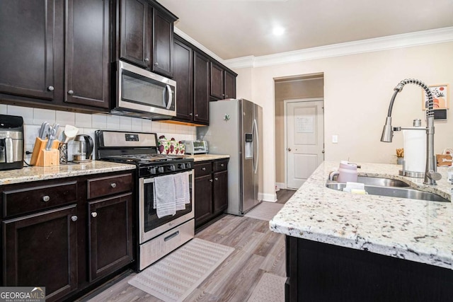 kitchen featuring appliances with stainless steel finishes, dark brown cabinets, crown molding, backsplash, and sink