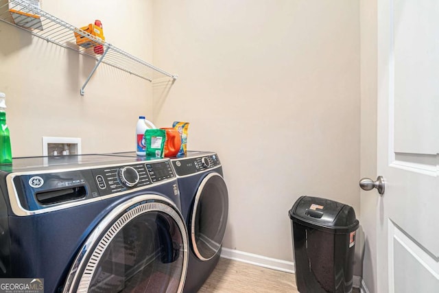 laundry area featuring washer and dryer and light hardwood / wood-style floors