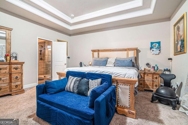 carpeted bedroom featuring a tray ceiling, ornamental molding, and ensuite bathroom