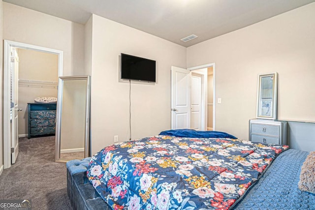 carpeted bedroom with a closet and a walk in closet