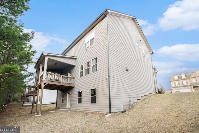 rear view of property featuring a wooden deck