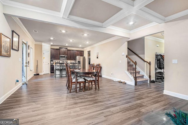 dining space featuring hardwood / wood-style flooring, beamed ceiling, ornamental molding, and coffered ceiling