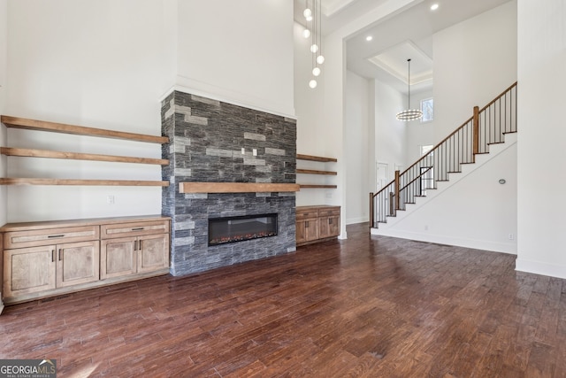 unfurnished living room with a high ceiling and dark hardwood / wood-style floors