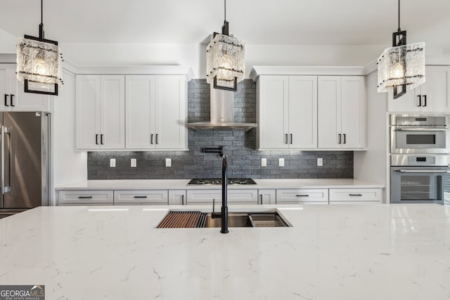 kitchen with white cabinets, hanging light fixtures, and light stone counters