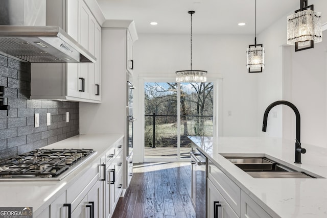 kitchen featuring sink, light stone counters, exhaust hood, white cabinets, and stainless steel gas cooktop