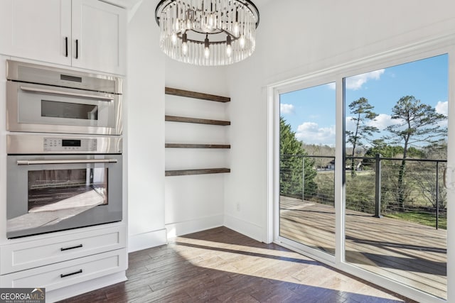 interior space with a chandelier and dark hardwood / wood-style floors