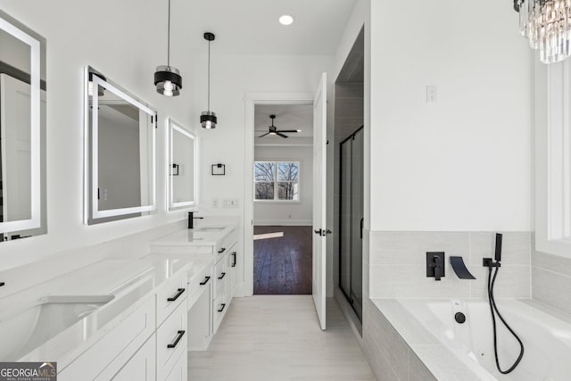 bathroom featuring hardwood / wood-style flooring, plus walk in shower, and vanity