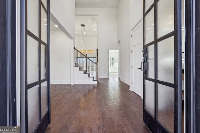 foyer with dark wood-type flooring and a towering ceiling