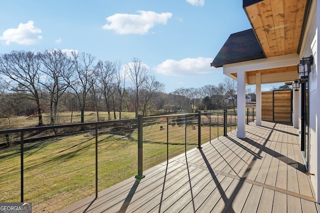 wooden terrace with a rural view and a yard