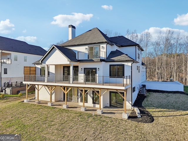 back of house featuring a lawn and a patio