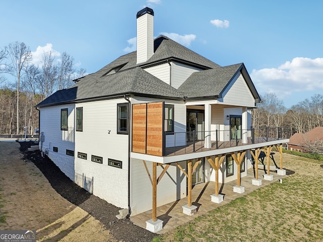 rear view of house featuring a lawn and a wooden deck