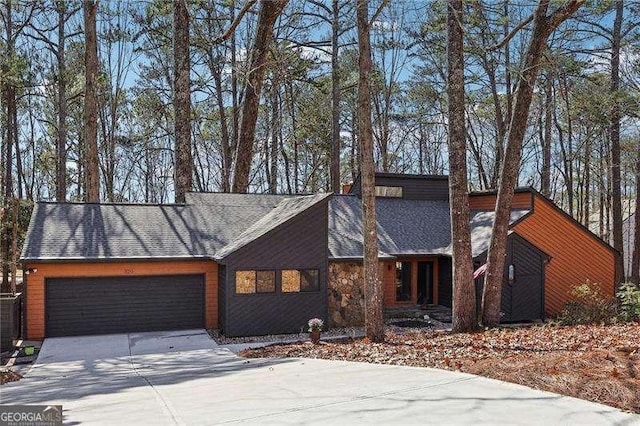 mid century modern with a garage and concrete driveway