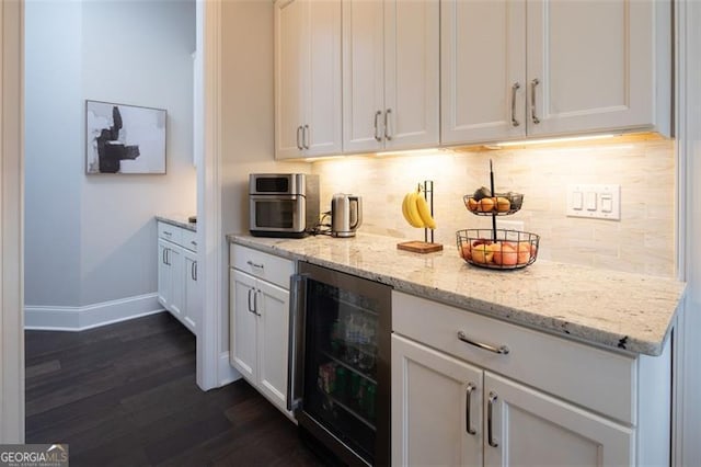 bar featuring dark wood-style floors, tasteful backsplash, wine cooler, and baseboards