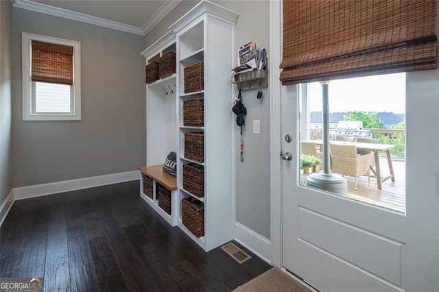 mudroom featuring dark wood finished floors, visible vents, crown molding, and baseboards