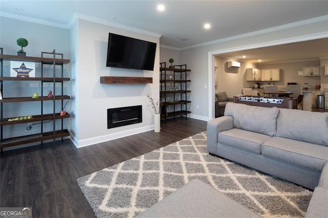 living area with recessed lighting, baseboards, ornamental molding, dark wood-style floors, and a glass covered fireplace