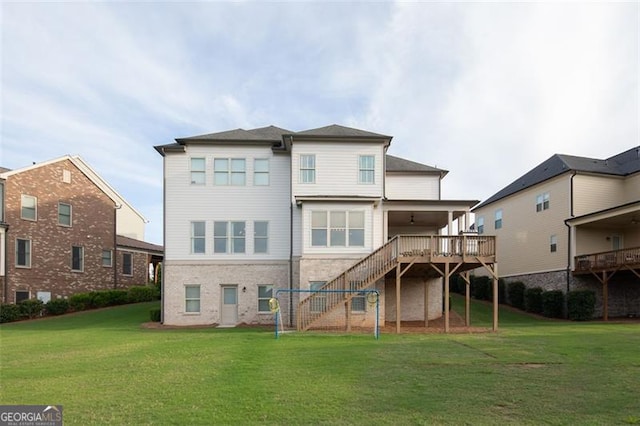 rear view of property featuring stairs, a deck, and a lawn