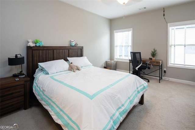 bedroom featuring visible vents, multiple windows, light carpet, and baseboards