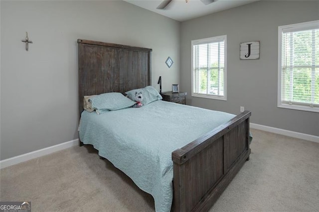 bedroom with light carpet, multiple windows, and baseboards