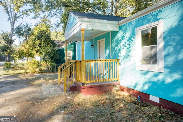 view of side of property featuring covered porch