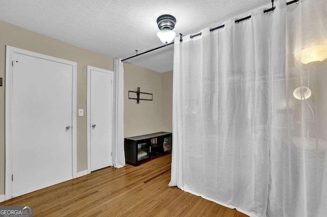 bathroom with a textured ceiling and hardwood / wood-style floors