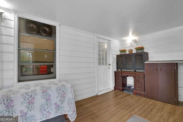 bedroom with wooden walls and wood-type flooring