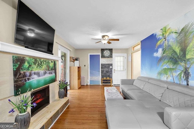 living room featuring ceiling fan, plenty of natural light, and wood-type flooring