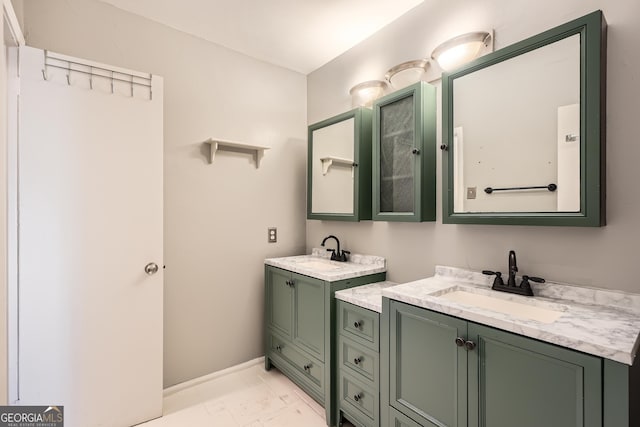 bathroom featuring marble finish floor, two vanities, a sink, and baseboards