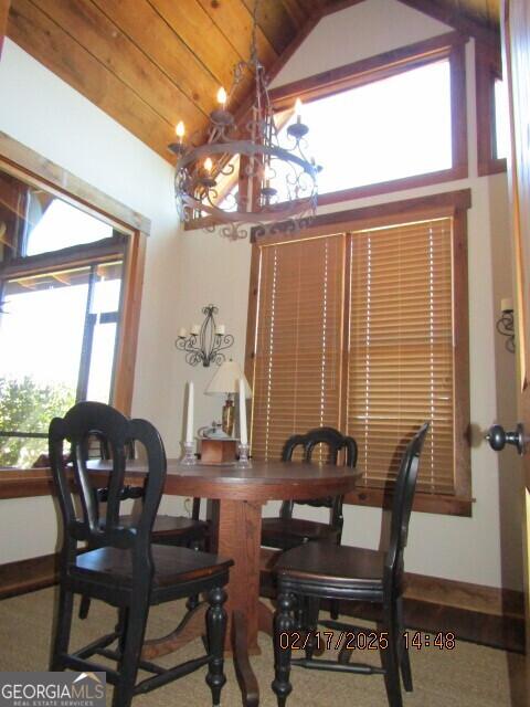 dining space with wood ceiling, an inviting chandelier, and lofted ceiling