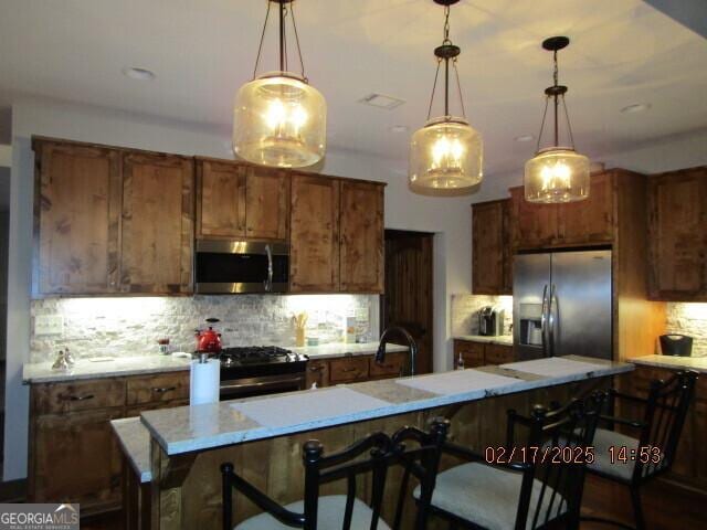 kitchen featuring a kitchen bar, appliances with stainless steel finishes, and a center island