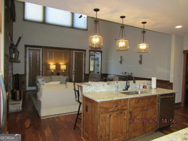 kitchen with sink, hanging light fixtures, dark hardwood / wood-style floors, and dishwasher