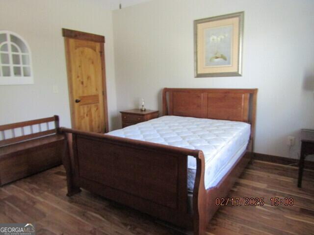 bedroom with dark wood-type flooring