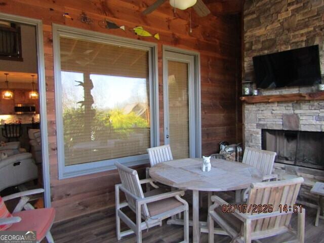 exterior space featuring a fireplace, wooden walls, and wood-type flooring