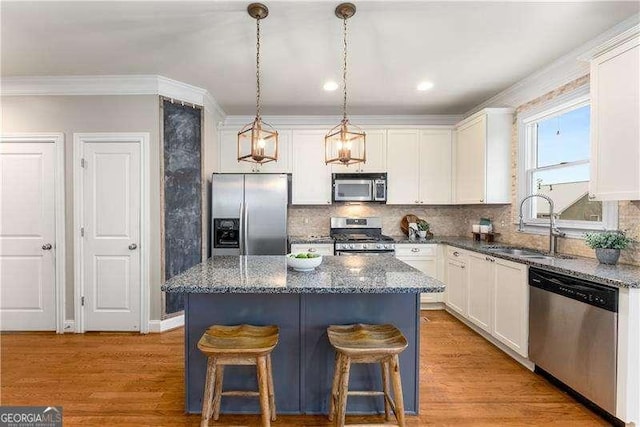 kitchen with appliances with stainless steel finishes, a kitchen island, and white cabinets