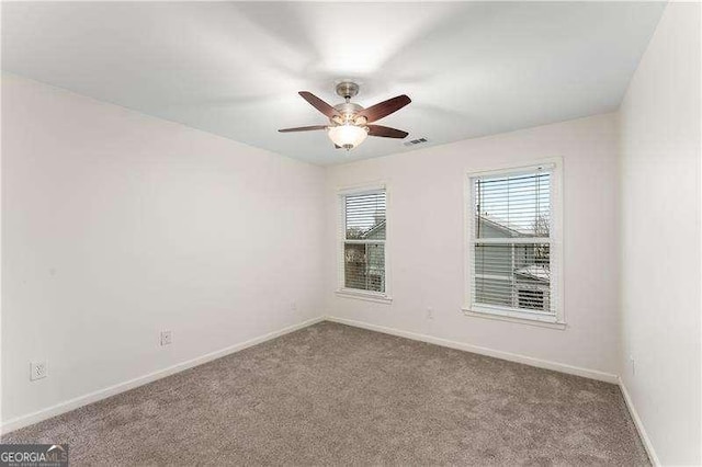 carpeted spare room featuring ceiling fan