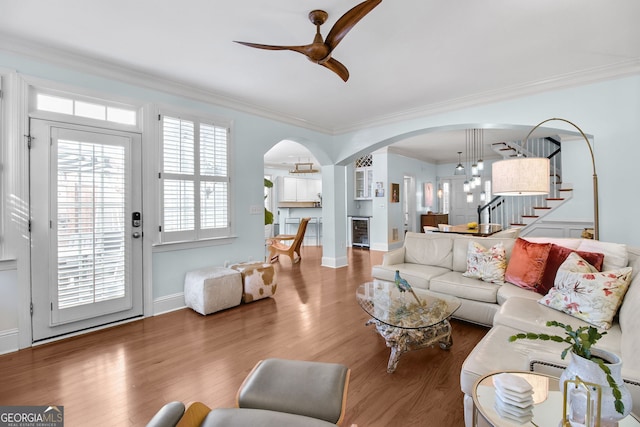 living room featuring ceiling fan, beverage cooler, dark hardwood / wood-style floors, and ornamental molding