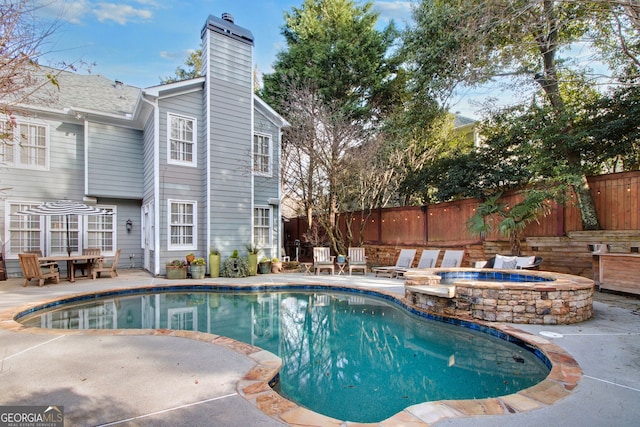 view of swimming pool featuring a patio and an in ground hot tub