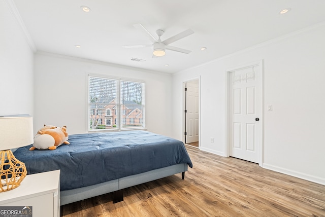 bedroom featuring hardwood / wood-style flooring, ornamental molding, and ceiling fan