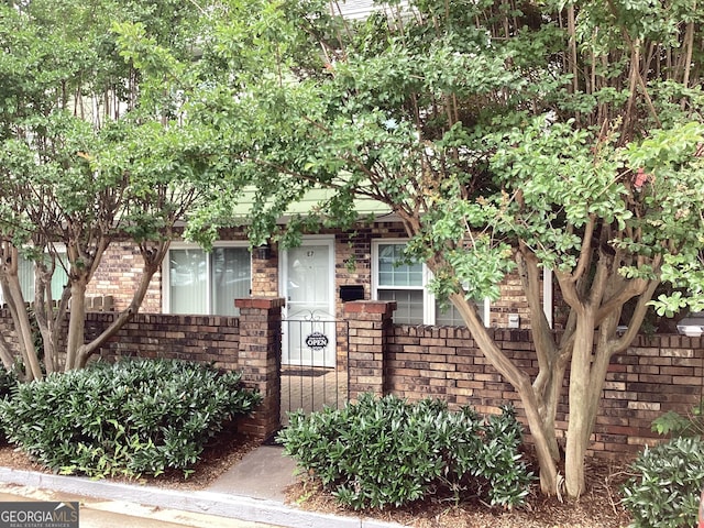 307 Adair St Unit E7, Decatur, GA 30030 - view of property hidden behind natural elements with brick siding and a fenced front yard