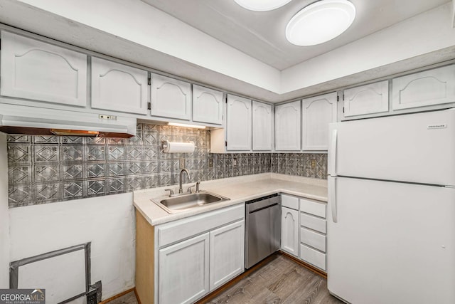 kitchen with sink, white cabinetry, white refrigerator, stainless steel dishwasher, and decorative backsplash