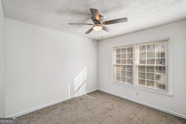 empty room featuring carpet flooring, baseboards, a textured ceiling, and ceiling fan