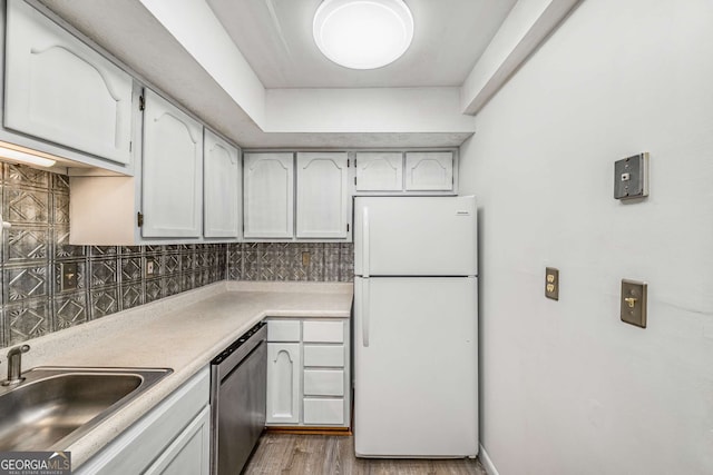 kitchen with freestanding refrigerator, dishwasher, backsplash, and a sink