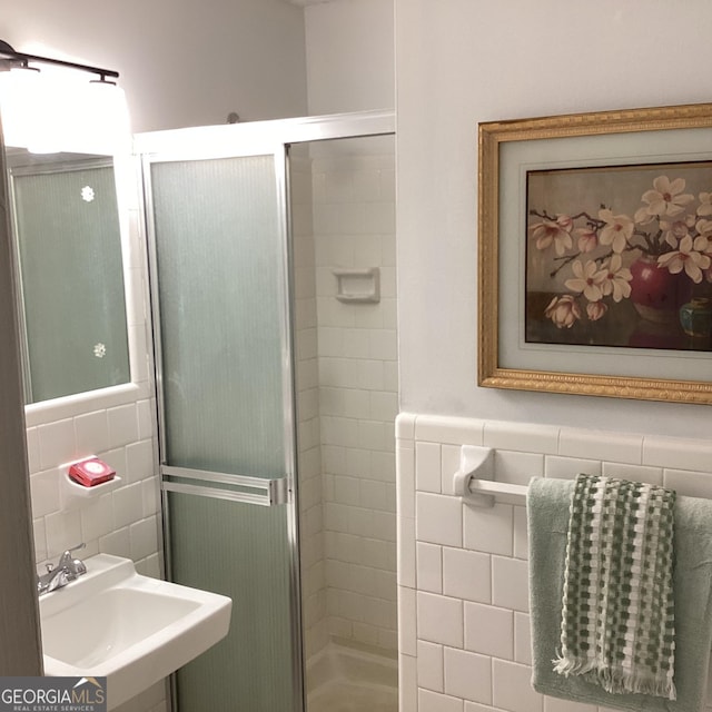 307 Adair St Unit E7, Decatur, GA 30030 - bathroom featuring tile walls, a sink, a stall shower, and a wainscoted wall
