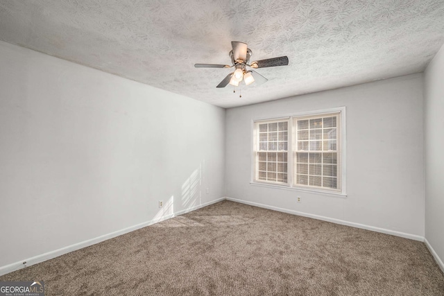 spare room with ceiling fan, carpet floors, baseboards, and a textured ceiling