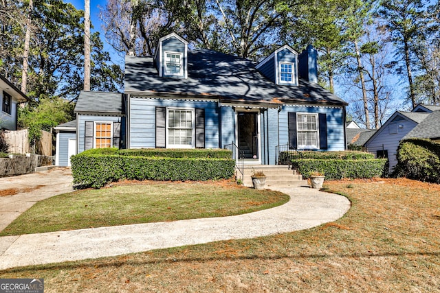 cape cod home featuring a front lawn and a garage