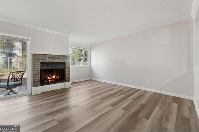 unfurnished living room with a fireplace, crown molding, and wood-type flooring