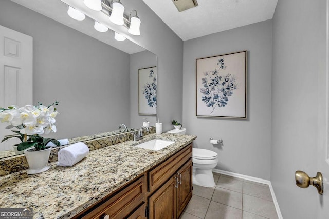 bathroom featuring baseboards, vanity, toilet, and tile patterned floors