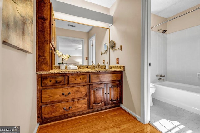 full bathroom featuring toilet, shower / bath combination, wood finished floors, vanity, and visible vents