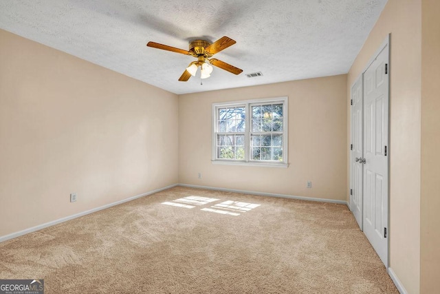 unfurnished bedroom featuring carpet flooring, a textured ceiling, and baseboards