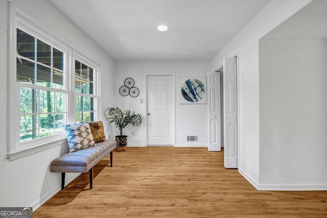 sitting room with light wood-style floors, baseboards, and visible vents