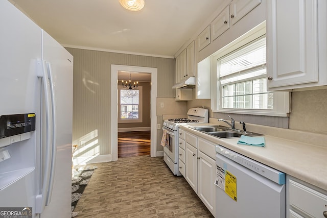 kitchen featuring white appliances, a chandelier, ornamental molding, sink, and white cabinetry
